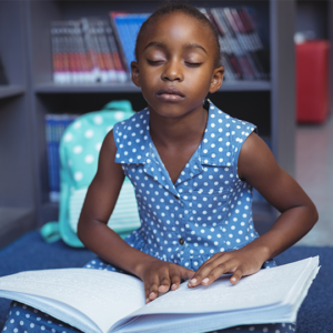 young african american blind girl reading a braille book