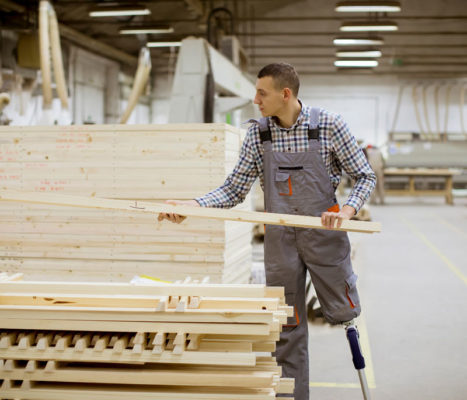 young man working pulling lumber while standing on prosthetic leg