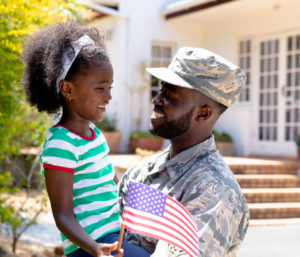 African American father holding his daughter and the flag.