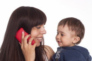 Mom talking on phone and holding her baby 